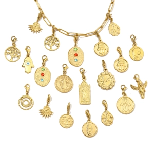 Various gold stainless steel pendants including tree of life and hamsa hand for jewelry making