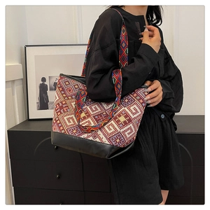 Close-up of ethnic geometric canvas tote bag with black PU leather base and wide strap