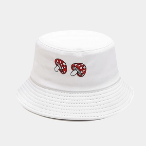 Close-up of detailed red mushroom embroidery on a white cotton bucket sun hat