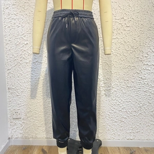Dettaglio dei pantaloni sportivi in pelle PU nera a vita alta con coulisse ed elastici