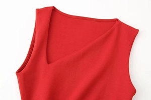 Macro shot of asymmetric neckline and neat stitching on red knitted dress fabric