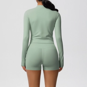 Rear view of slim fit yoga set featuring high-waisted shorts and green long sleeve top