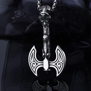 Macro shot of silver stainless steel viking battle axe pendant with skull details