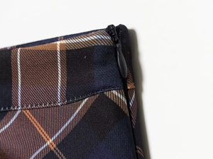 Detail view of plaid cloak dress featuring brown checkered fabric and invisible zipper