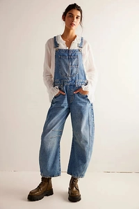 Detail of retro washed blue denim overalls with front pocket and loose straight-leg fit