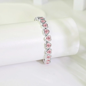 Close-up of heart-shaped pink zircon stones set in polished silver bracelet links