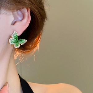 Detail macro view of 18k gold plated green crystal butterfly stud earring for women