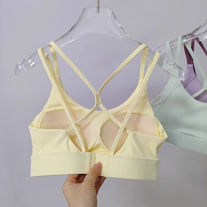 Close-up of adjustable back clasp and cross straps on yellow high-impact sports bra