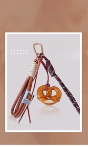Detailed close-up of pretzel pendant keychain with woven cord and brown alloy carabiner