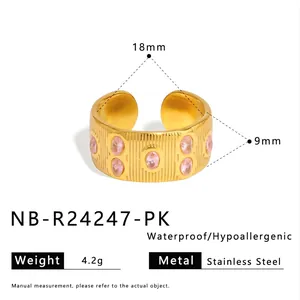 Detail van de vergulde roestvrijstalen ring met roze stenen en verticale texturen