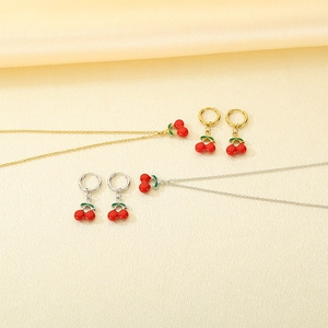 Detail of red enamel cherry jewelry sets in gold and silver stainless steel finish