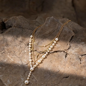 Detail of layered gold necklace with imitation pearls and crystal crescent moon charm