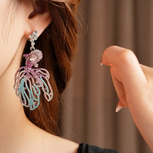 Gros plan de boucles d'oreilles vintage poisson rouge avec strass colorés sur un mannequin