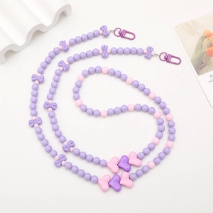 Detail of pink and purple acrylic beaded phone strap with bow and heart charms