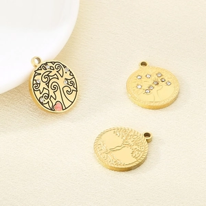 Detailed macro of stainless steel Tree of Life pendants with crystal and pink heart accents
