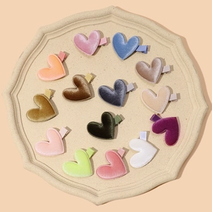 Set of 14 colorful velvet heart hair clips for girls displayed on a vintage tray
