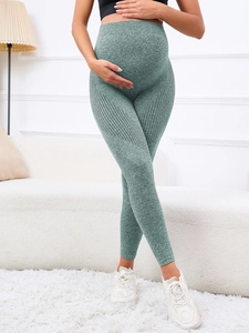 Macro detail of seamless maternity yoga leggings showing stretch fabric and belly support