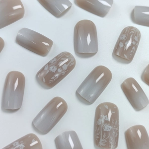 Glossy nude grey gradient press-on nails featuring delicate white floral leaf designs