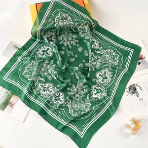 Detailed view of dark green silk square scarf with classic white paisley pattern