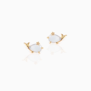 Detailed view of whale-shaped stud earrings with light blue stones and gold metal frame