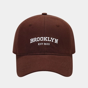 Detailed close-up of BROOKLYN embroidery on dark coffee cotton baseball cap