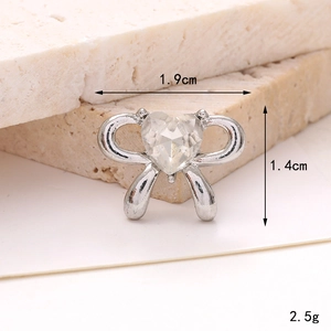 Macro view of silver bow charm with heart crystal showing 1.9cm width and 1.4cm height