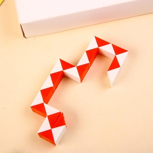 Detail of red and white 24 segments folding magic snake puzzle toy on a beige table