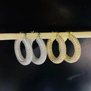 Macro detail of gold and silver hoop earrings with micro-pave white zircon stones