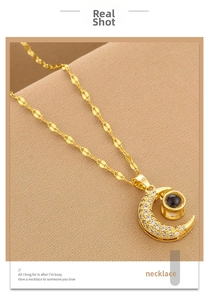 Macro shot of gold crescent moon pendant with micro-pave diamonds and leaf chain