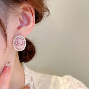 Vintage portrait cameo earrings with faux pearls and gold finish on female model