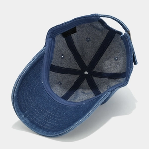 Detail view of denim baseball cap interior featuring 100% cotton stitching and metal buckle
