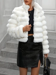 Detail of white faux fur coat featuring plush horizontal stitching and thick warm texture