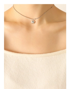 Gros plan du collier argenté Lucky avec pendentif gravé sur une chaîne de style serpent