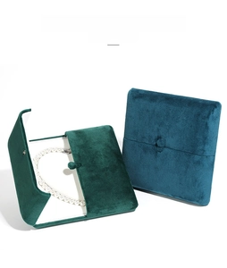 Detail of velvet pearl necklace boxes in emerald green and sky blue with double doors