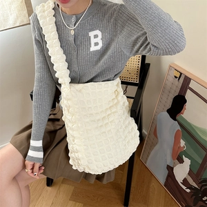 Detail view of the cream white tote bag featuring bubble texture and ruffled shoulder straps