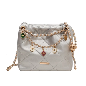 Silver quilted bucket bag with gold chain and heart pendants on white background