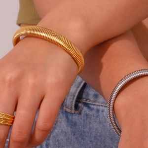 Gros plan de bracelets chaîne serpent et bagues assorties plaqués or 18 carats et argent