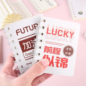 Mini A7 spiral notebook with cute motivational patterns held in hand on pink background
