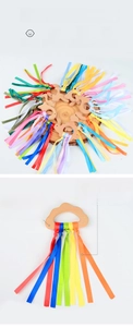 Detail of beech wood baby ring with colorful ribbons for sensory grip and molar relief