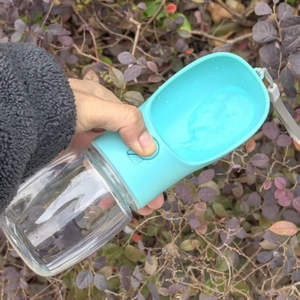 Close-up of portable pet water bottle with teal trough and a convenient wrist strap