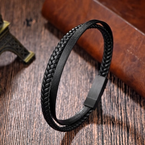 Macro detail of black double-layer leather bracelet with magnetic metal clasp on wood