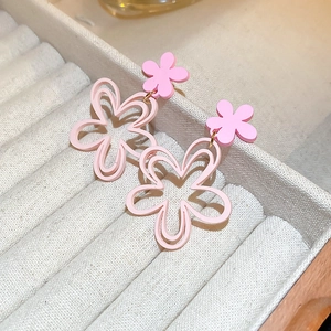 Macro detail of pink mesh flower earrings with tassel petals in a jewelry box