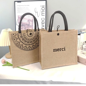 Detail showing natural jute tote bag texture with merci print and mandala design