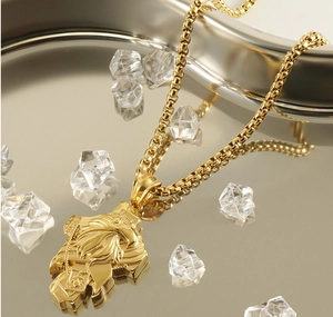 Close-up of golden eagle head pendant on a box chain with luxury crystal decor