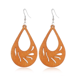 Detailed view of hollow leaf pattern teardrop wooden earrings with silver hooks