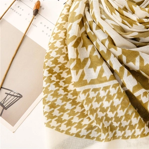 Detailed texture of ginger yellow houndstooth scarf with soft fringe and fabric weave
