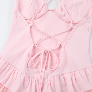 Detailed view of the pink ruffled hem and sexy lace-up back design on this romper
