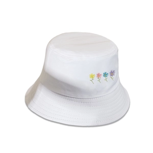Détail de quatre broderies de marguerites colorées sur le côté d'un bob blanc