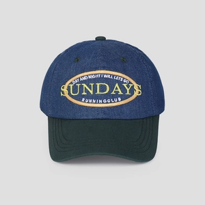 Detail of Sunday Running Club embroidery on navy denim and green brim baseball cap