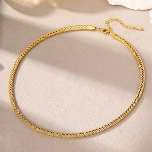 Detail of gold flat snake bone chain with wheat grain texture and lobster clasp
